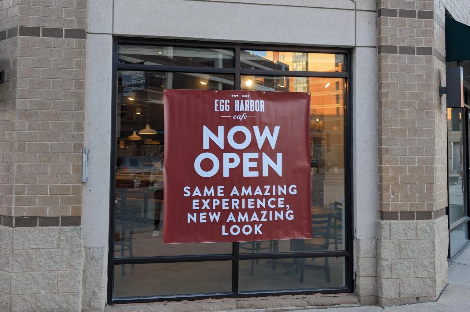 Restaurant exterior with a grand opening banner