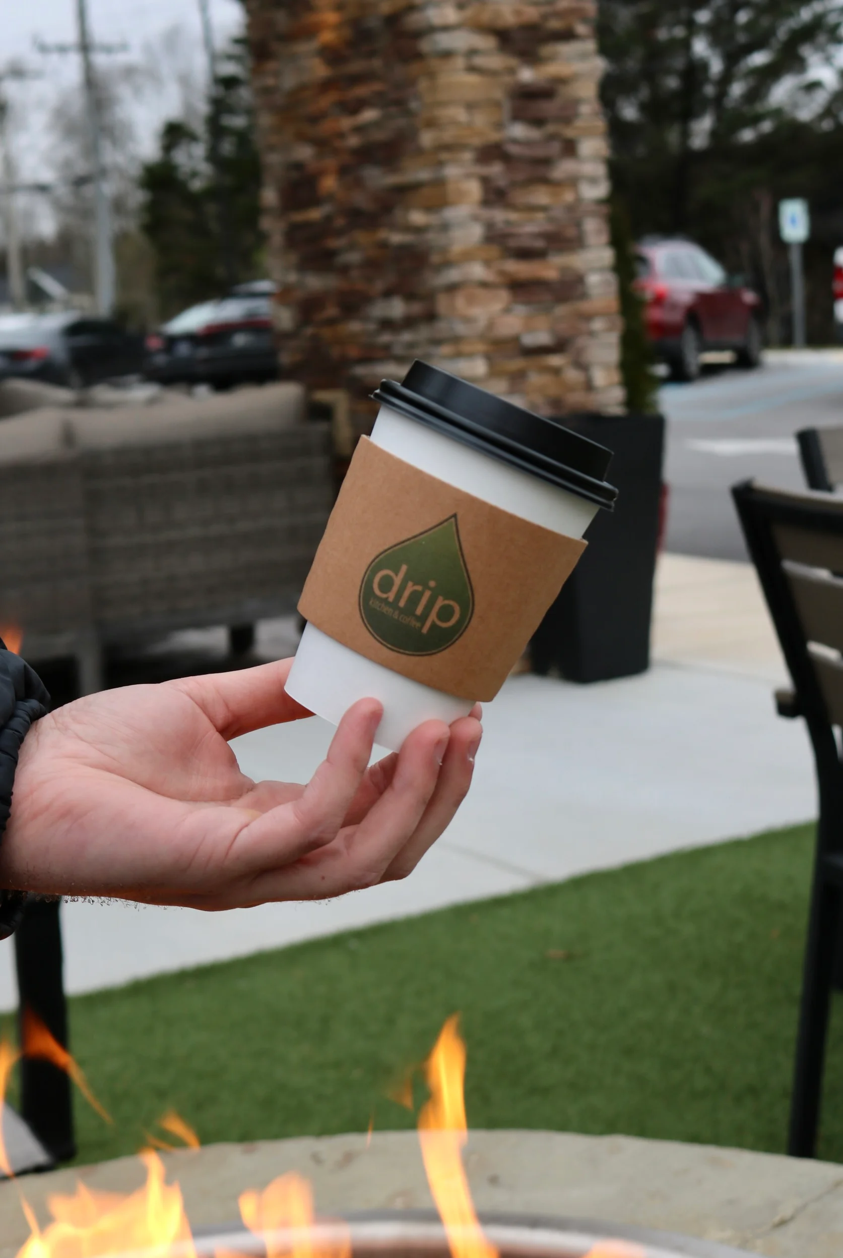 Hand holding a coffee cup from Drip Coffee Shop