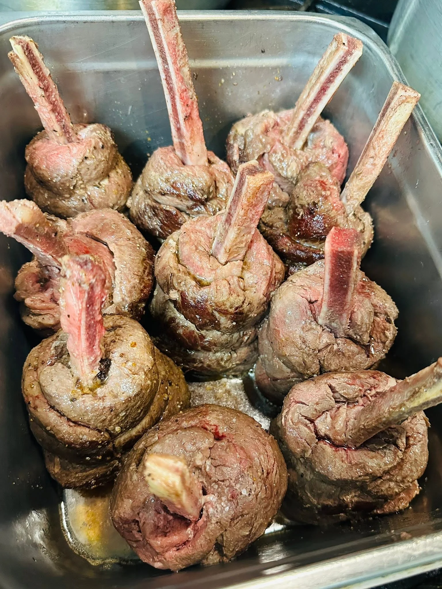 Tender lamb shanks prepared for slow cooking in a restaurant kitchen