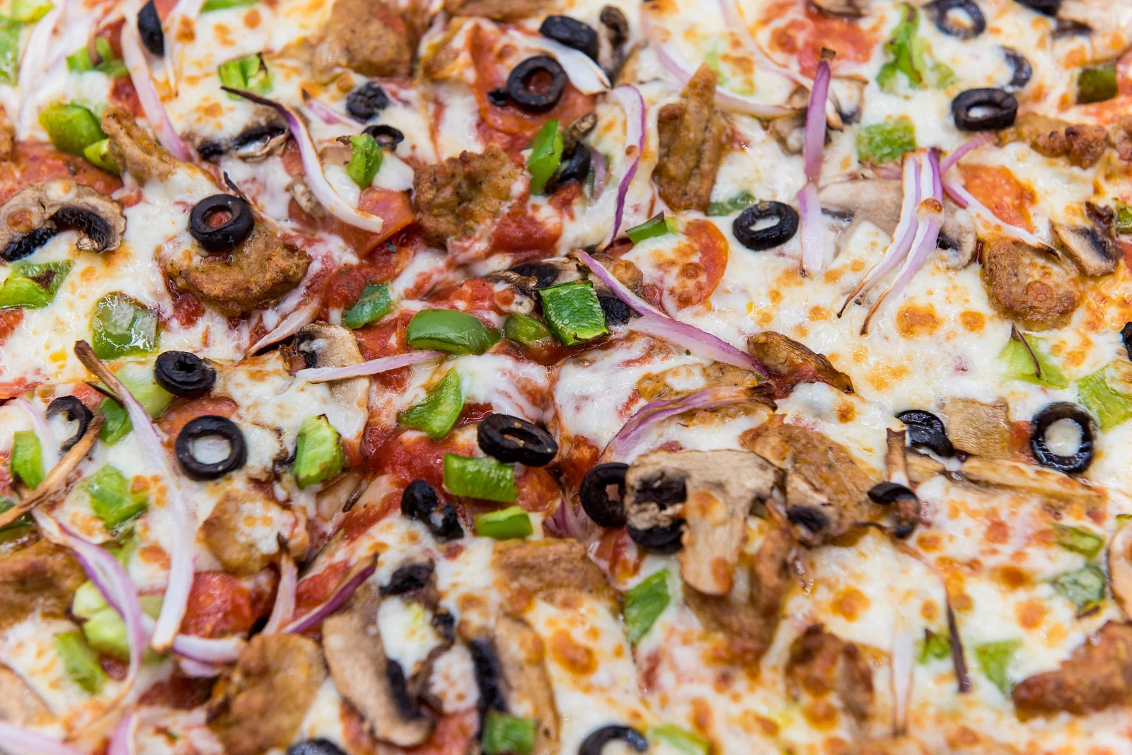 Delicious meat lover's pizza topped with cheese and vegetables