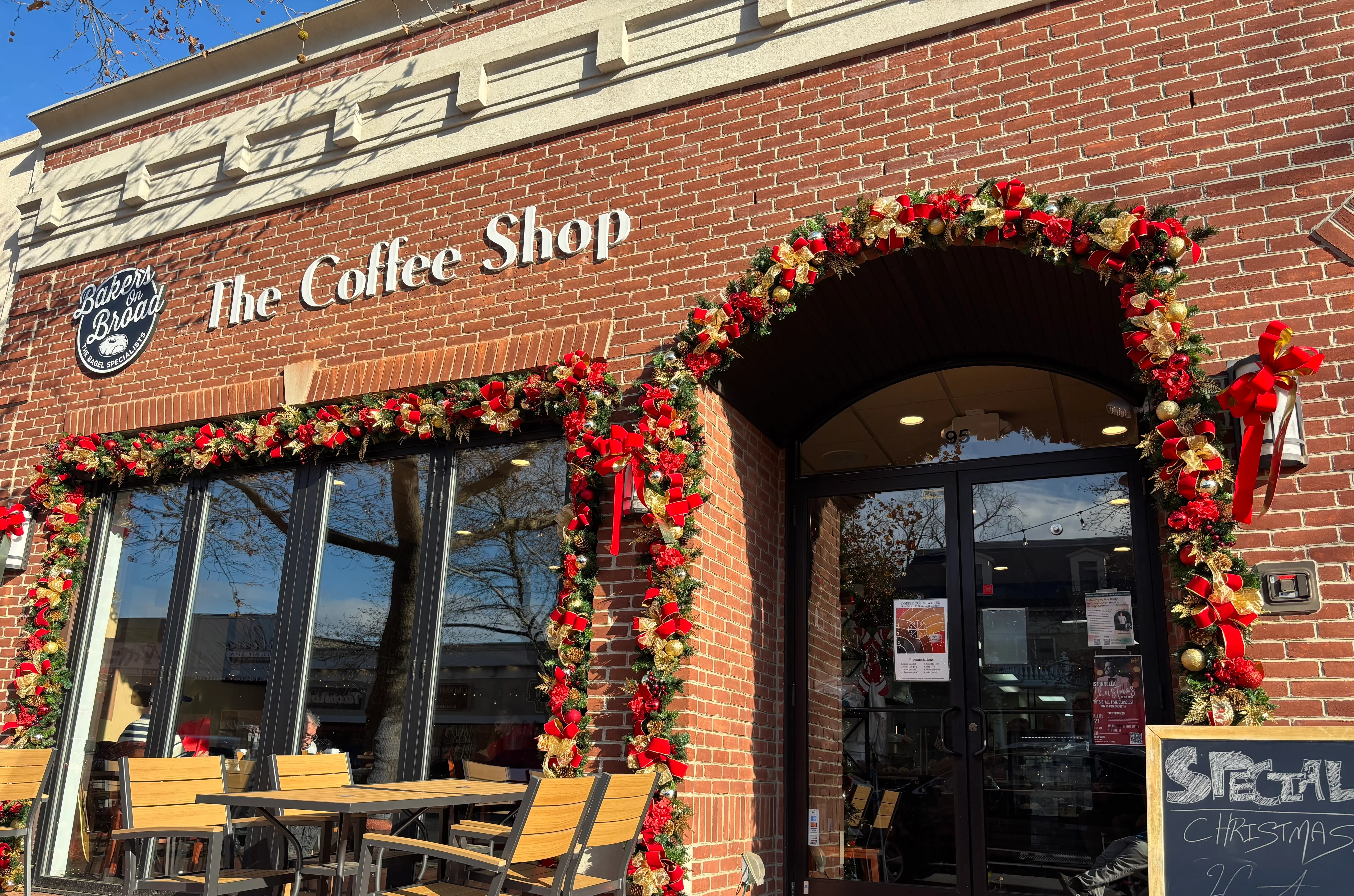 Festively decorated coffee shop entrance with holiday wreaths