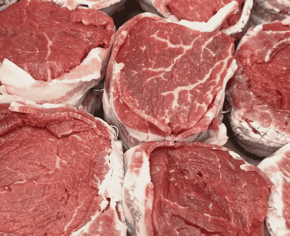 Close-up of fresh cuts of red meat arranged in a display.
