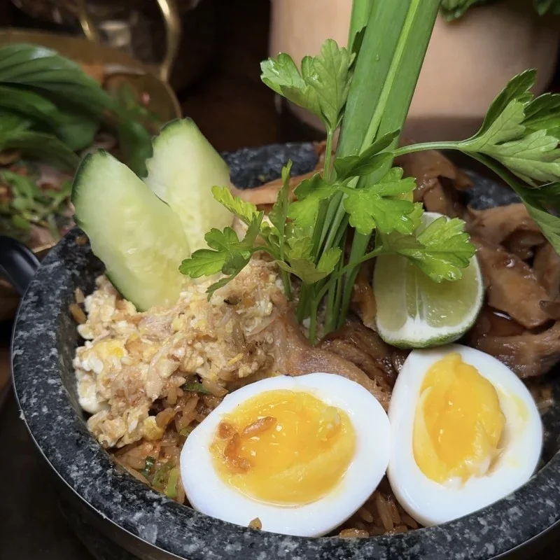 Indonesian nasi goreng served in a stone bowl with garnishes