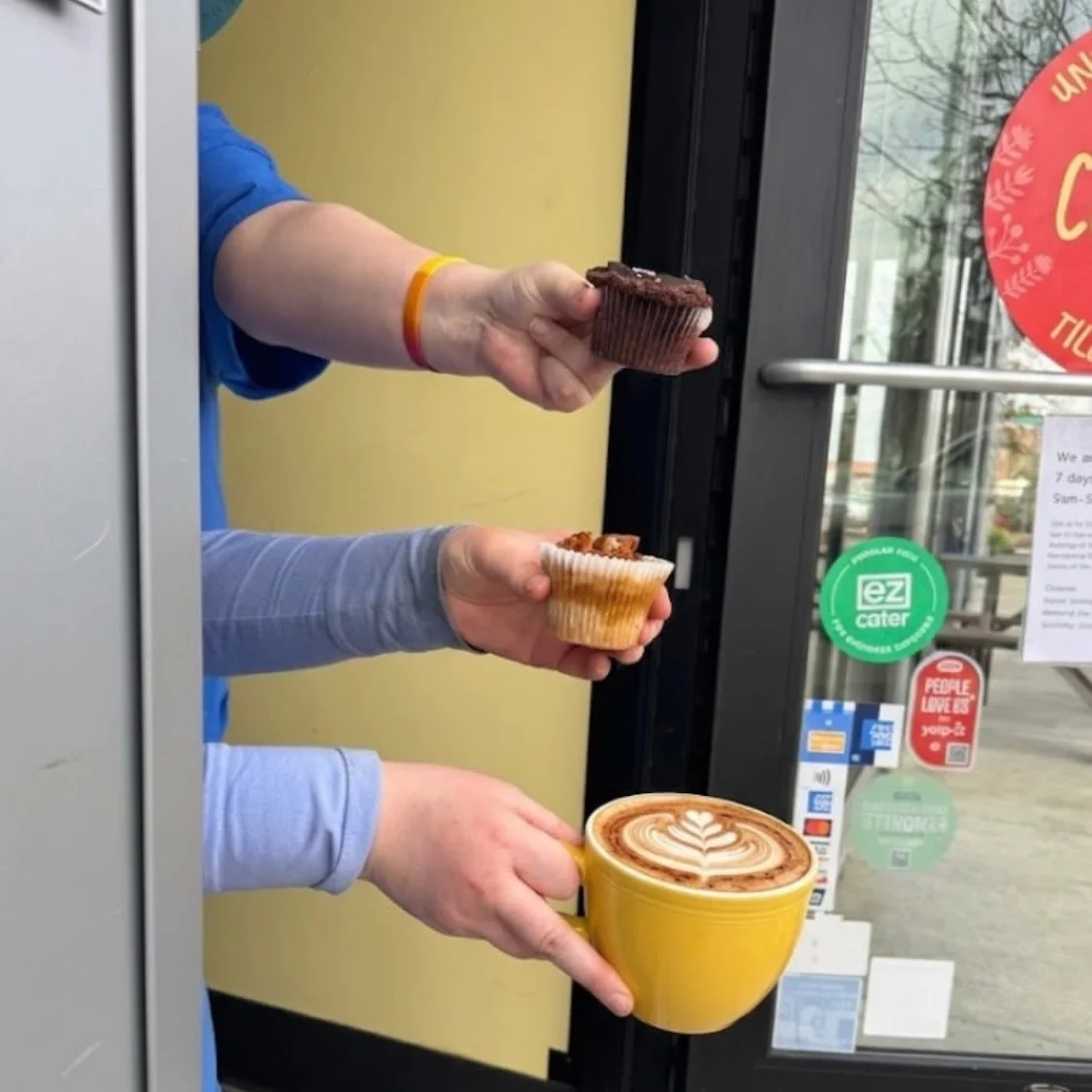 Coffee with latte art and two assorted cupcakes