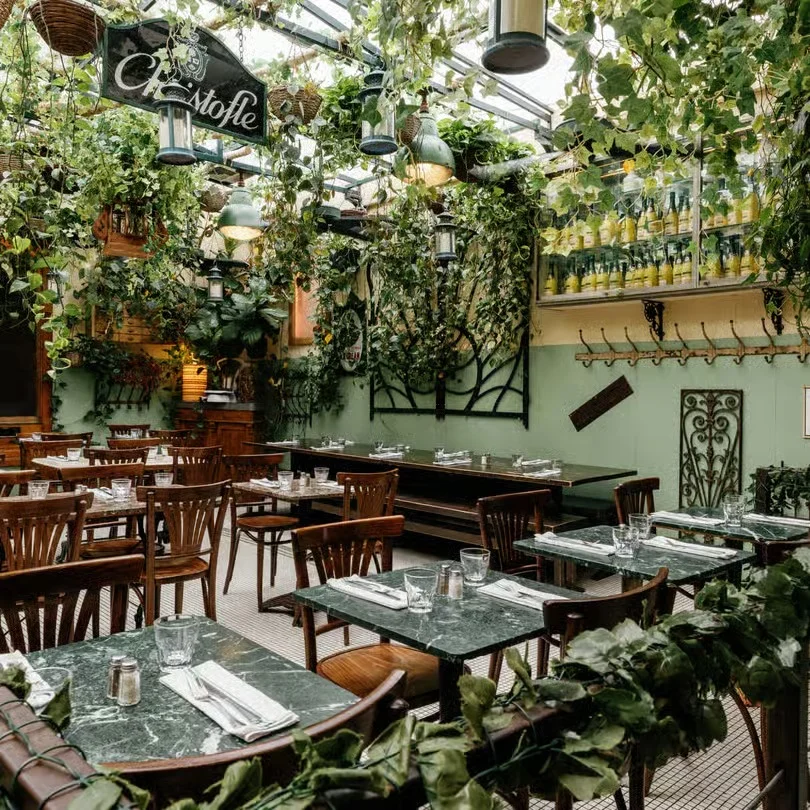 Lush restaurant interior with greenery and wooden furniture