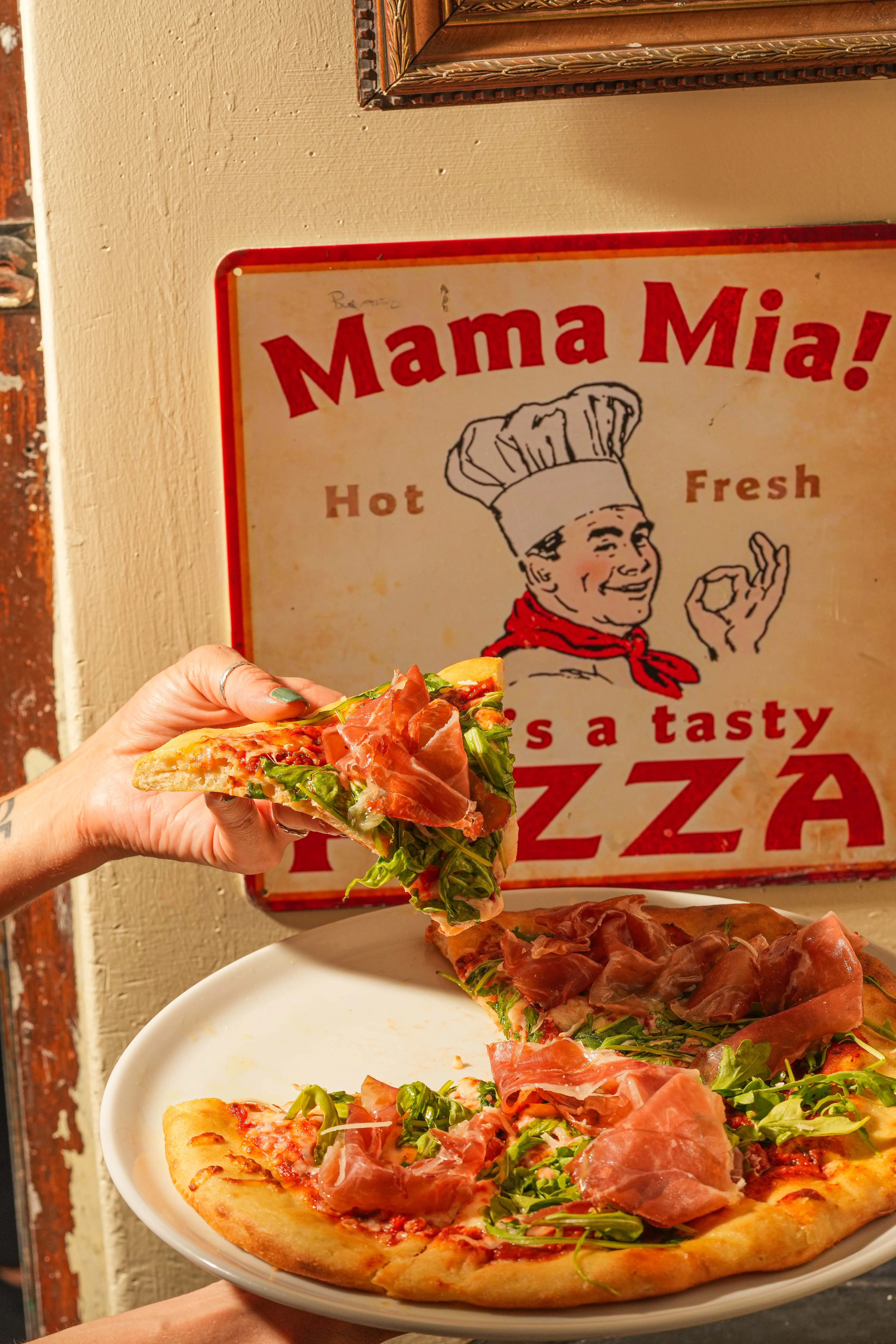 Delicious prosciutto pizza with fresh greens