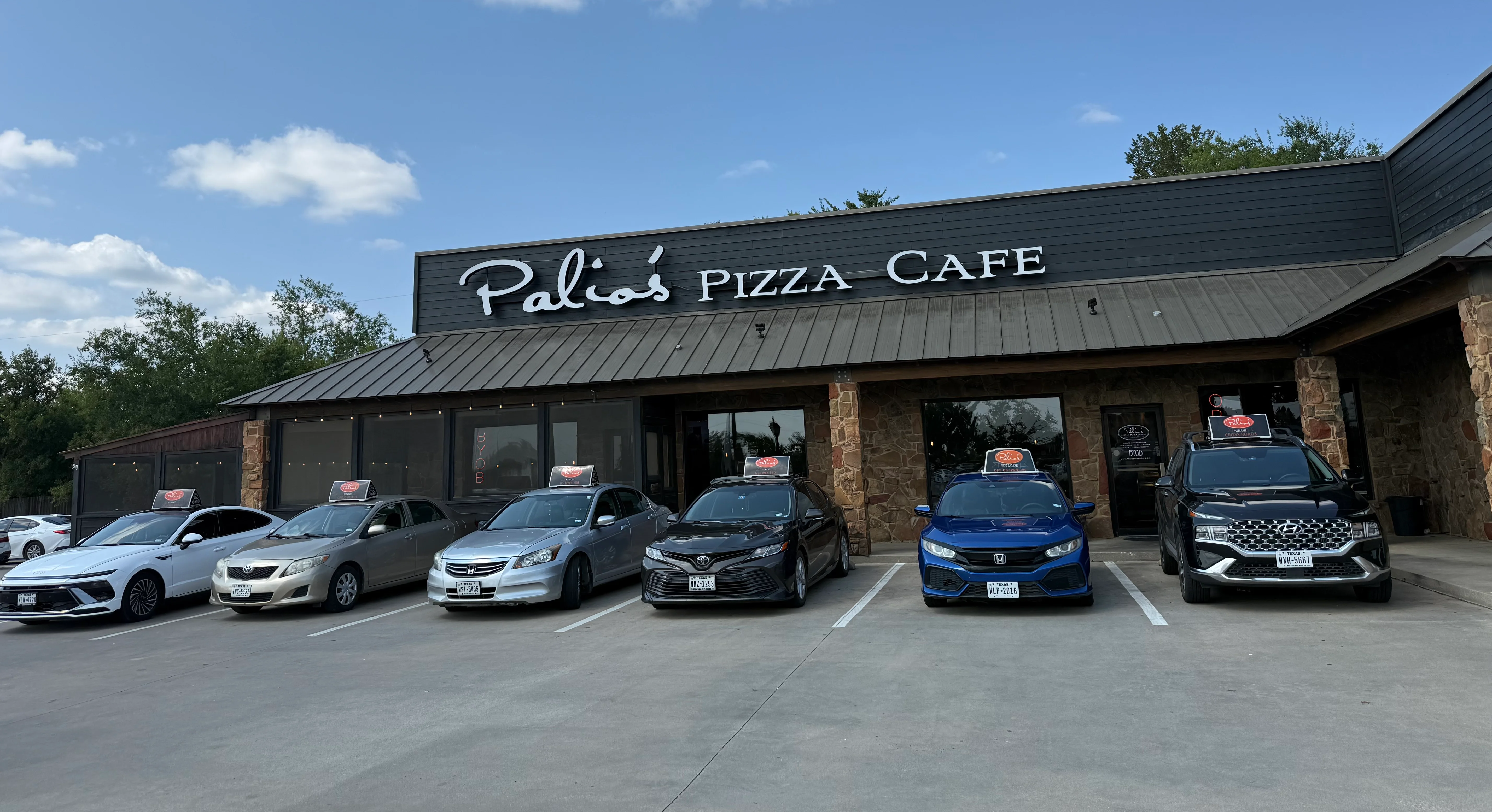 Exterior view of Palio's Pizza Cafe with parked cars