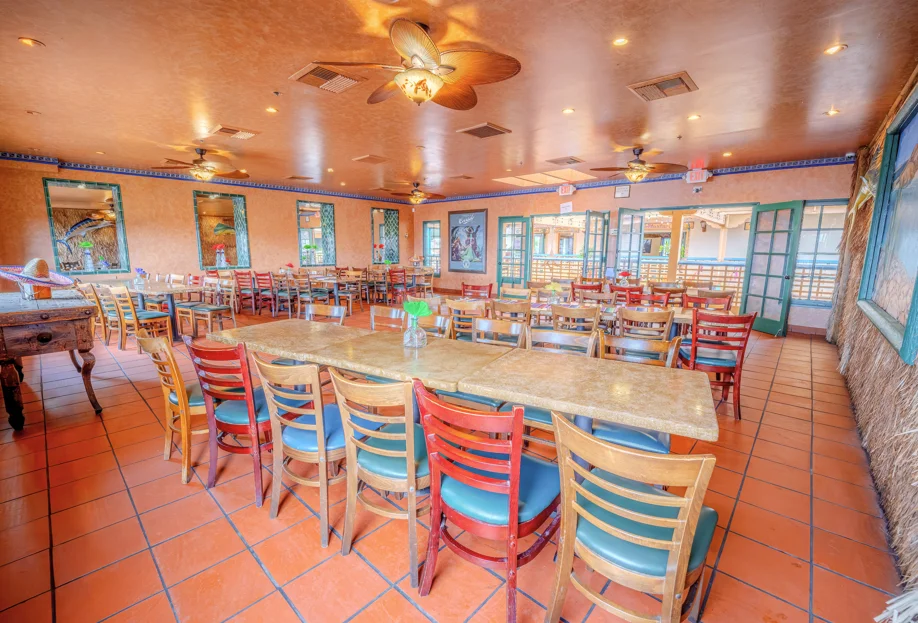Colorful restaurant interior with wooden chairs and tropical decor