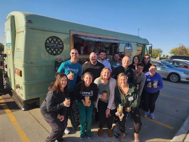 Group of people enjoying coffee from a food truck