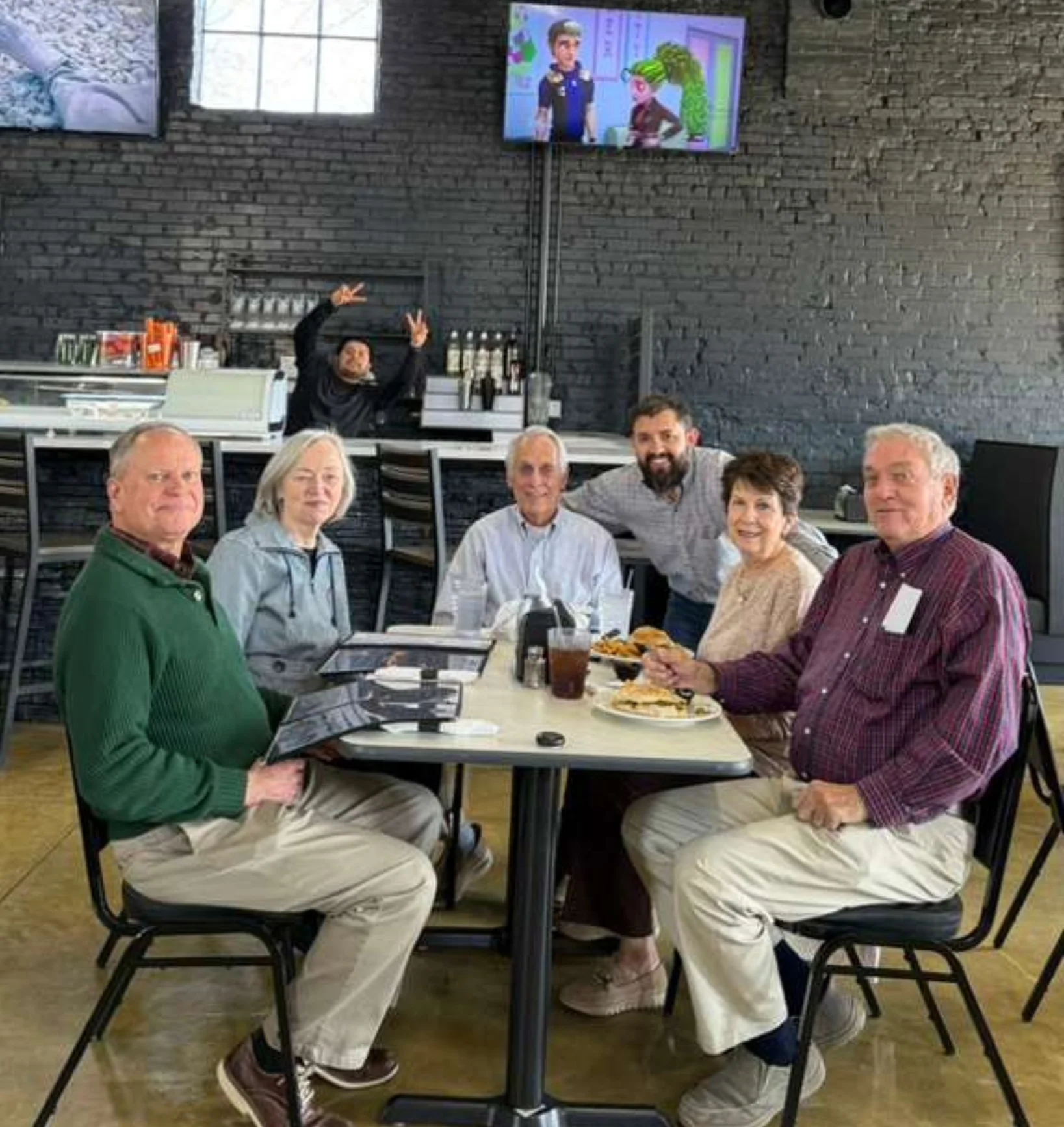 Group of friends enjoying a meal in a cozy restaurant setting