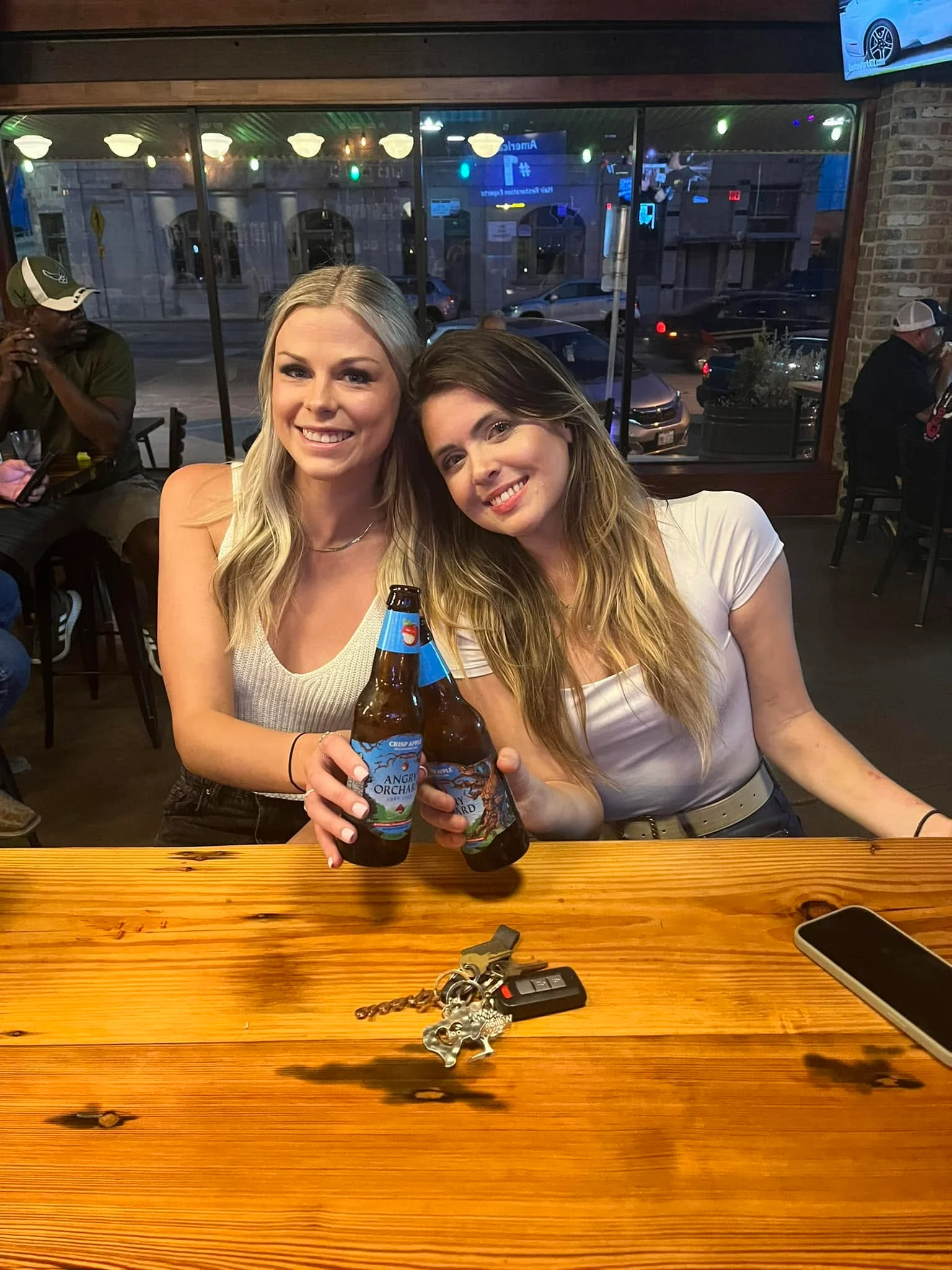 Two friends enjoying drinks at a lively bar