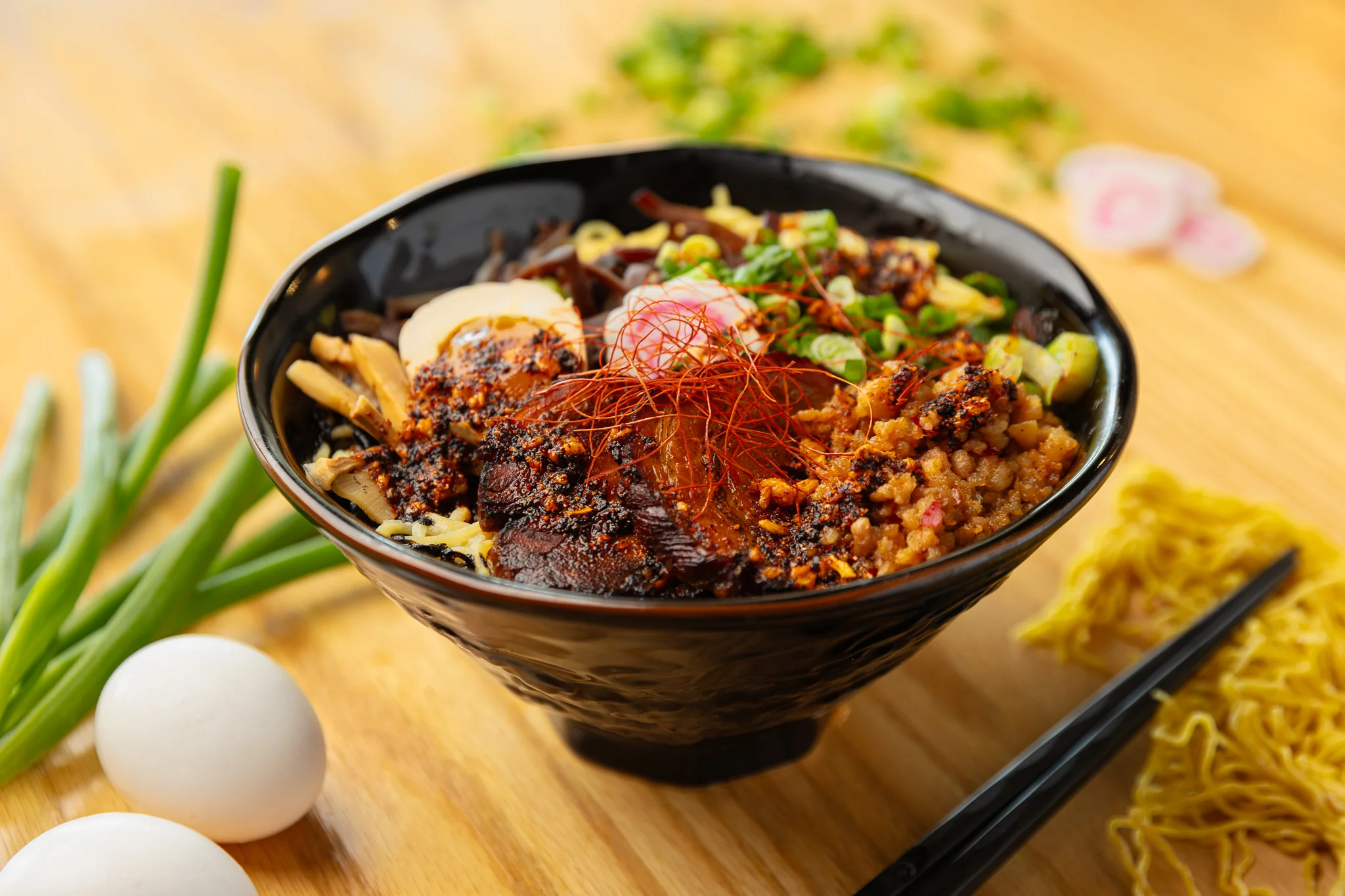 Spicy Sichuan dan dan noodles in a black bowl
