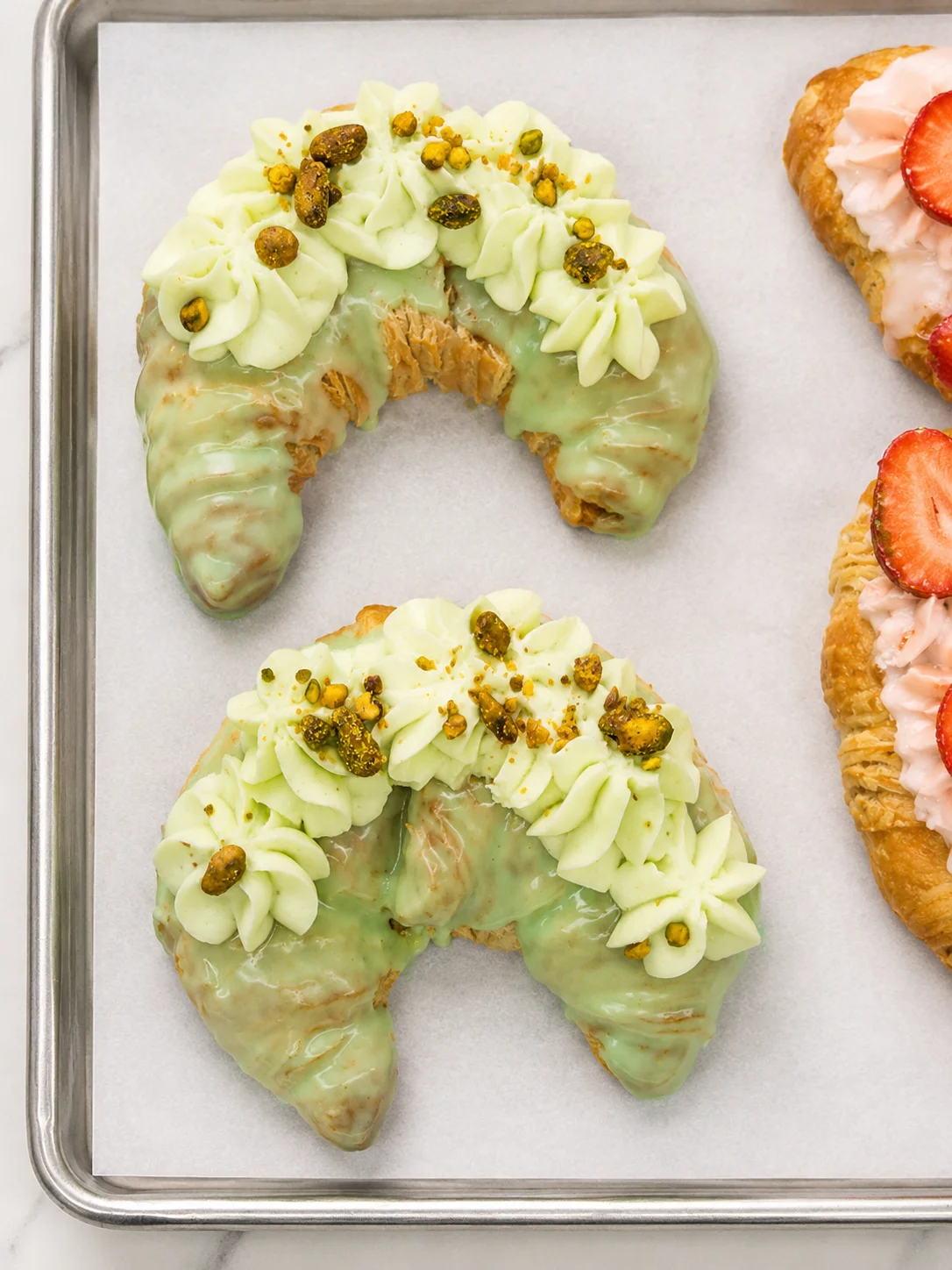 Pistachio croissant with green icing and decorative frosting