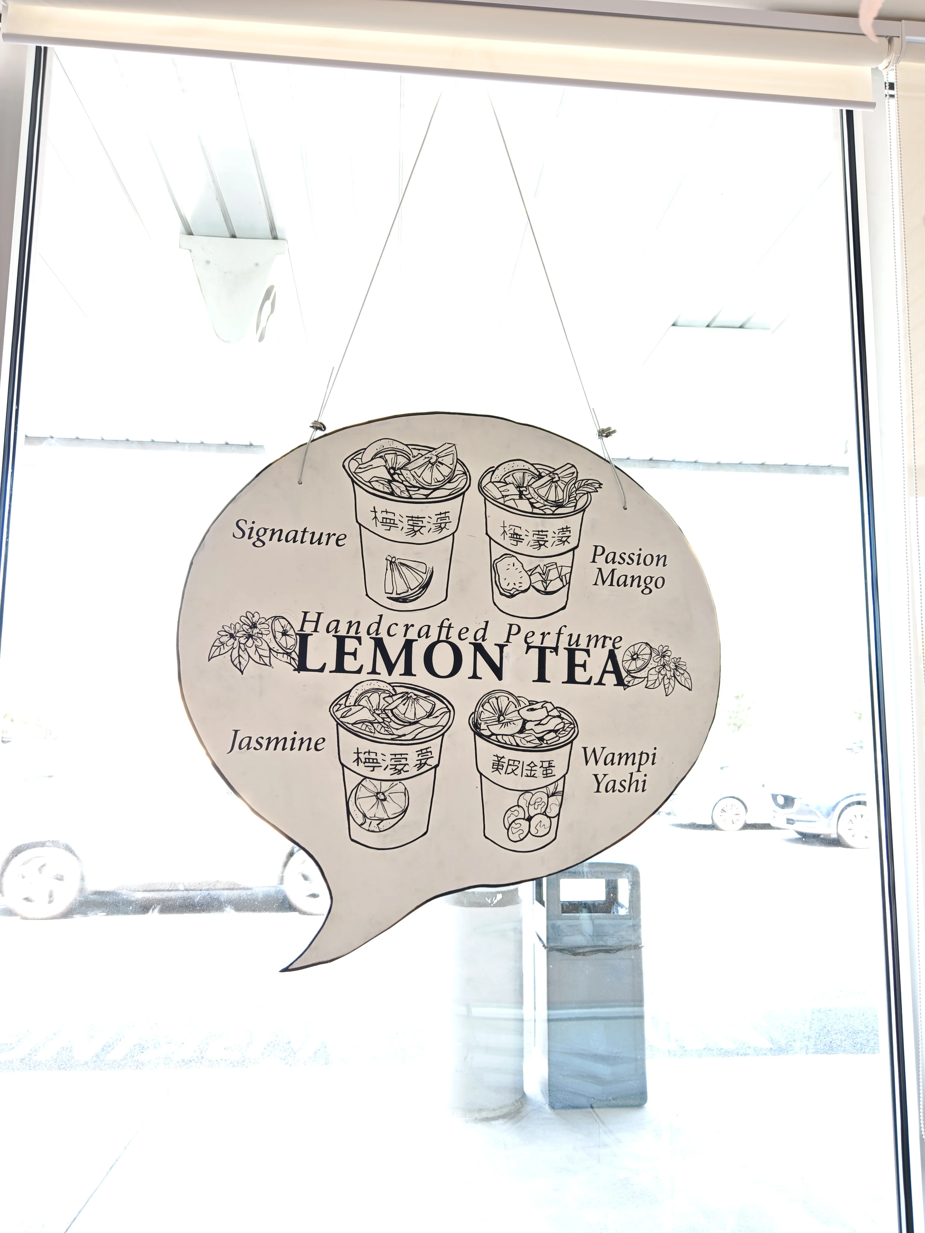 A window sign in the style of a drawing advertising Handcrafted Perfume Lemon Tea, a specialty drink available at Chopsticks Charm.