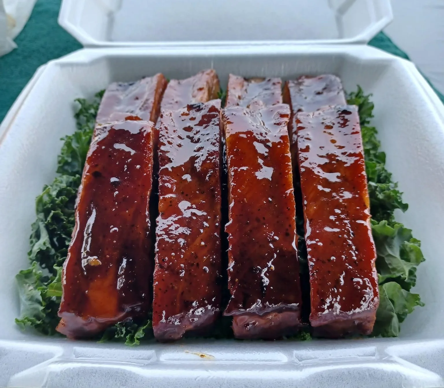 Barbecue glazed ribs served on a bed of greens