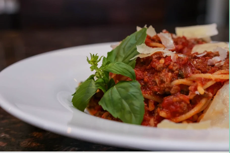 Plate of classic spaghetti bolognese with fresh basil