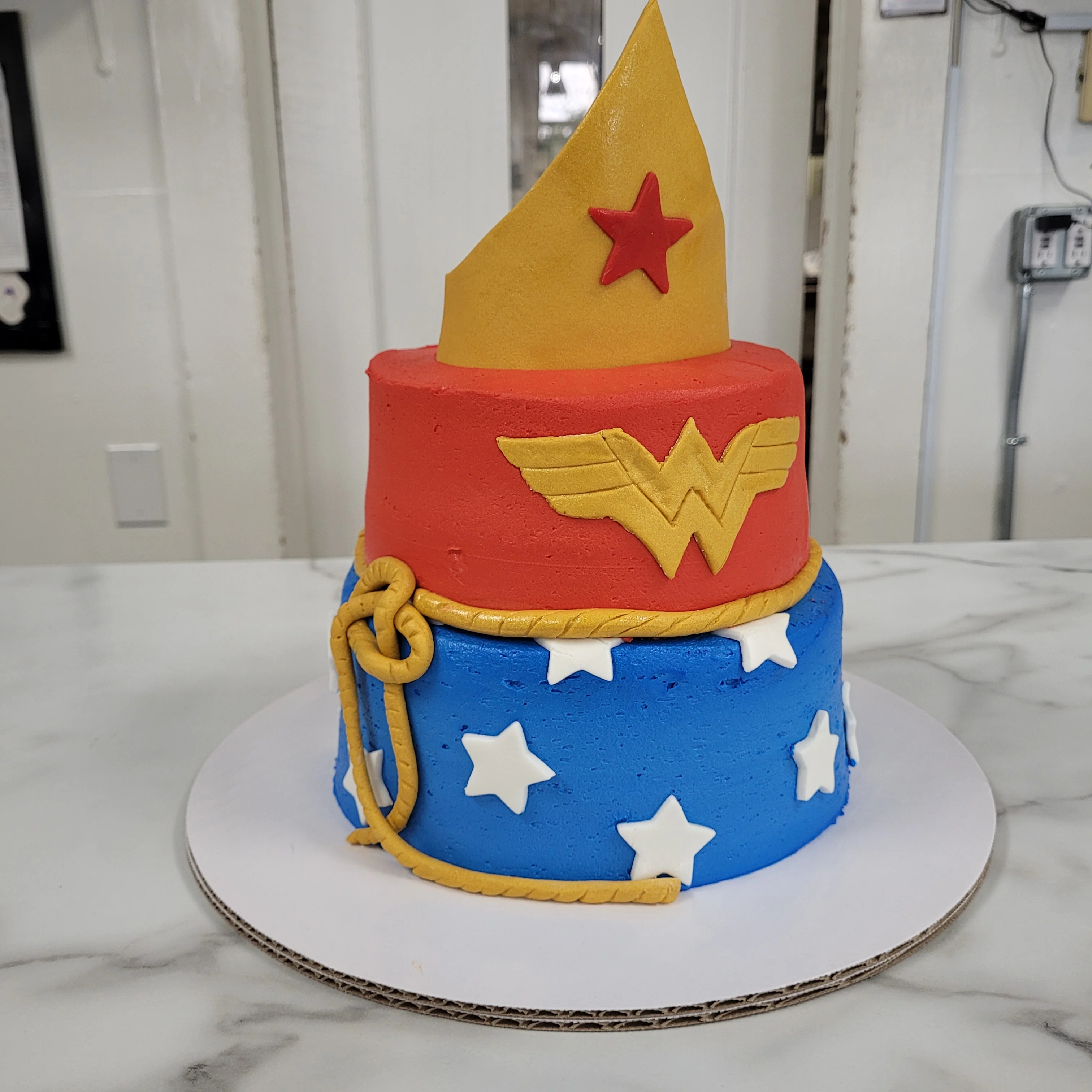 Colorful Wonder Woman themed cake with stars and gold accents
