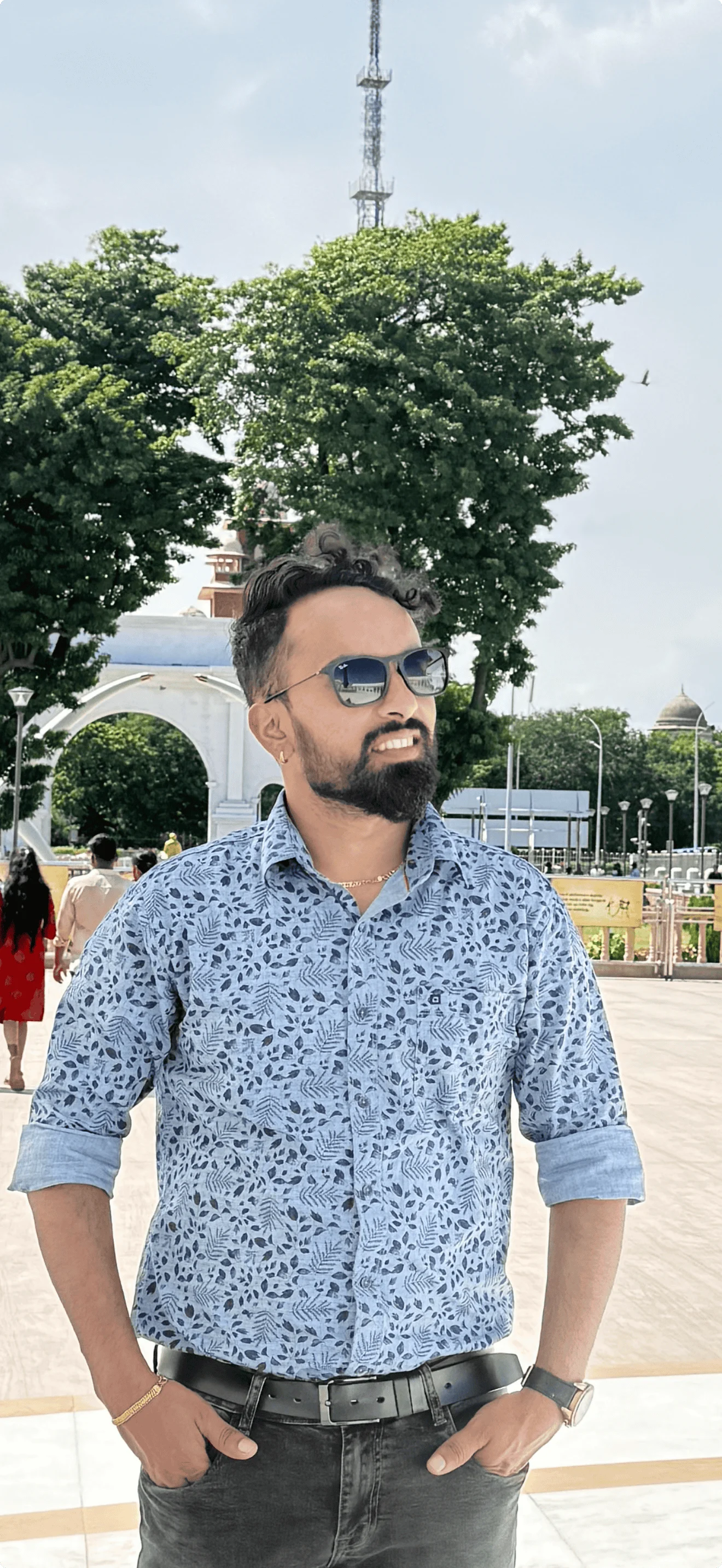 Man posing outdoors with sunglasses and floral shirt