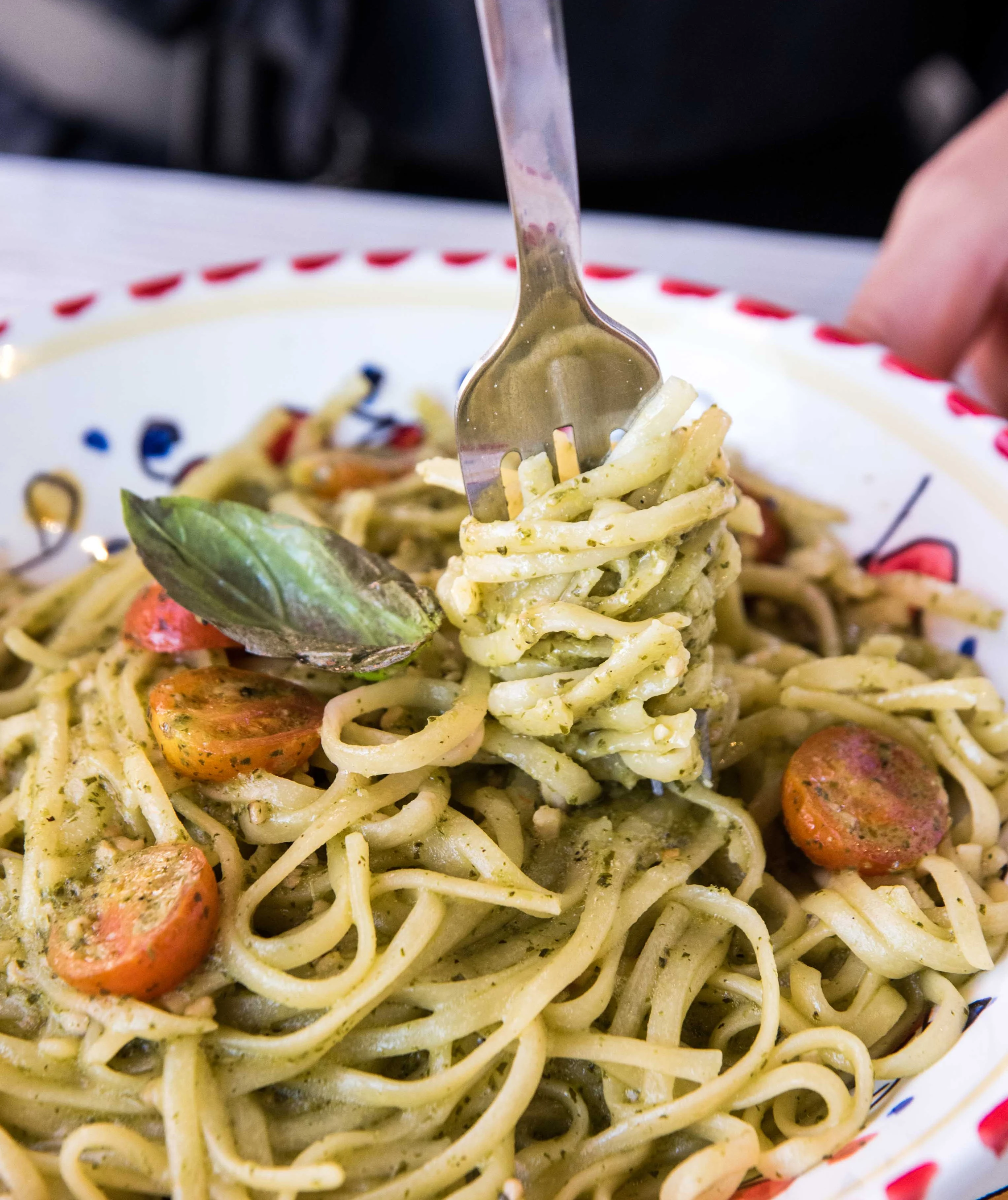 Plate of Italian pesto spaghetti with cherry tomatoes