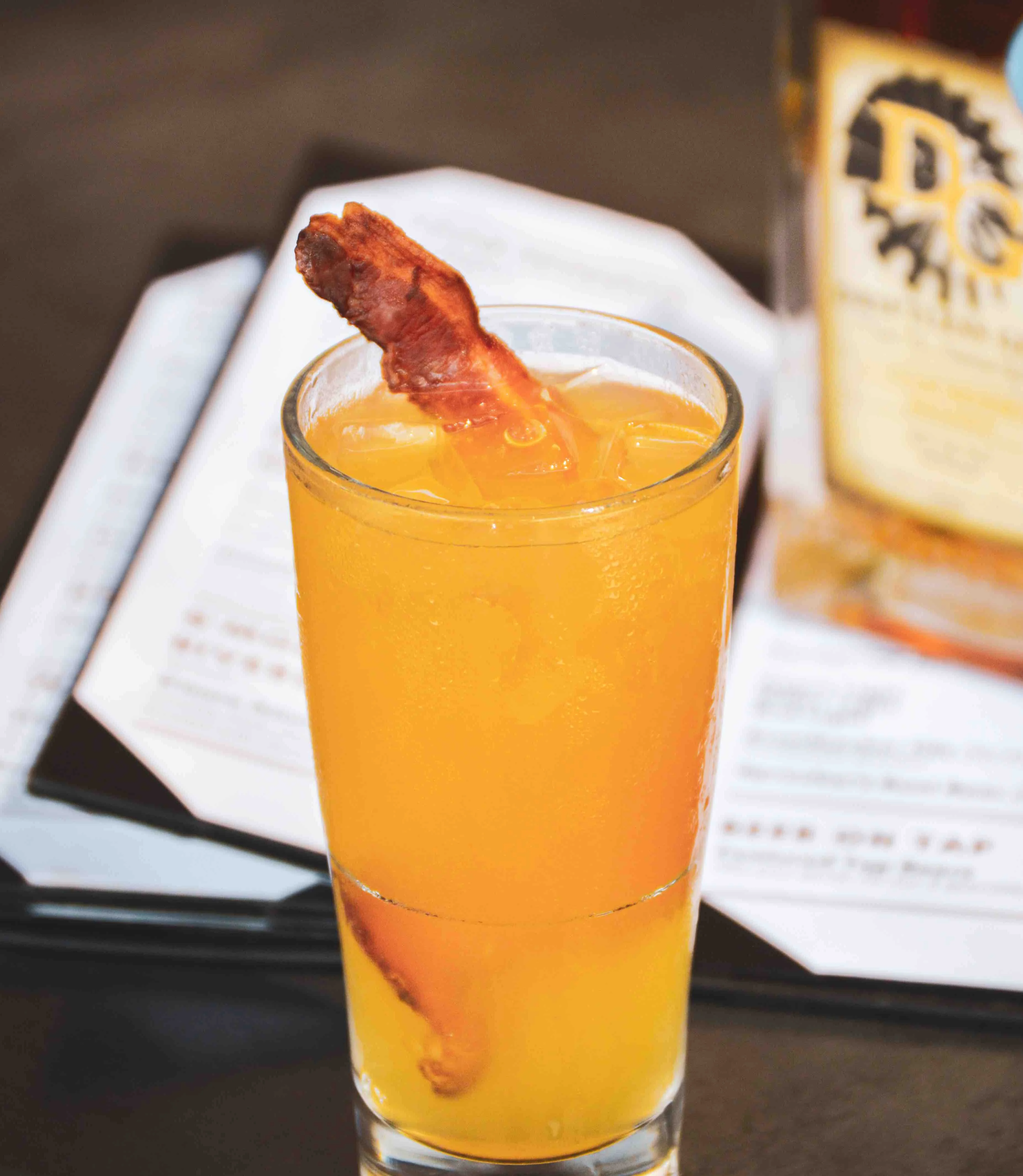 Oak & Smoke cocktail in front of a menu on the table