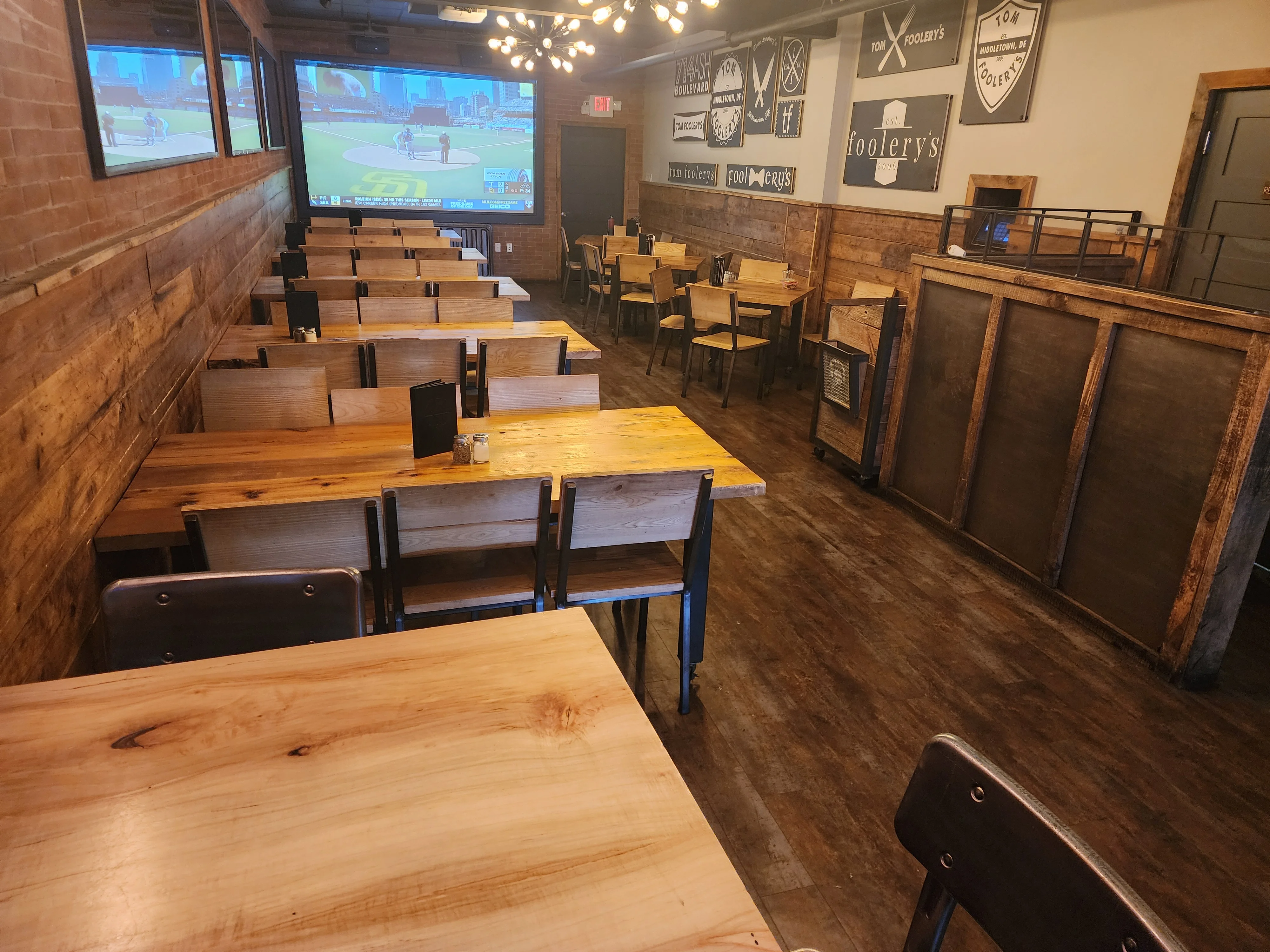 Cozy restaurant interior with wooden tables and sports screen