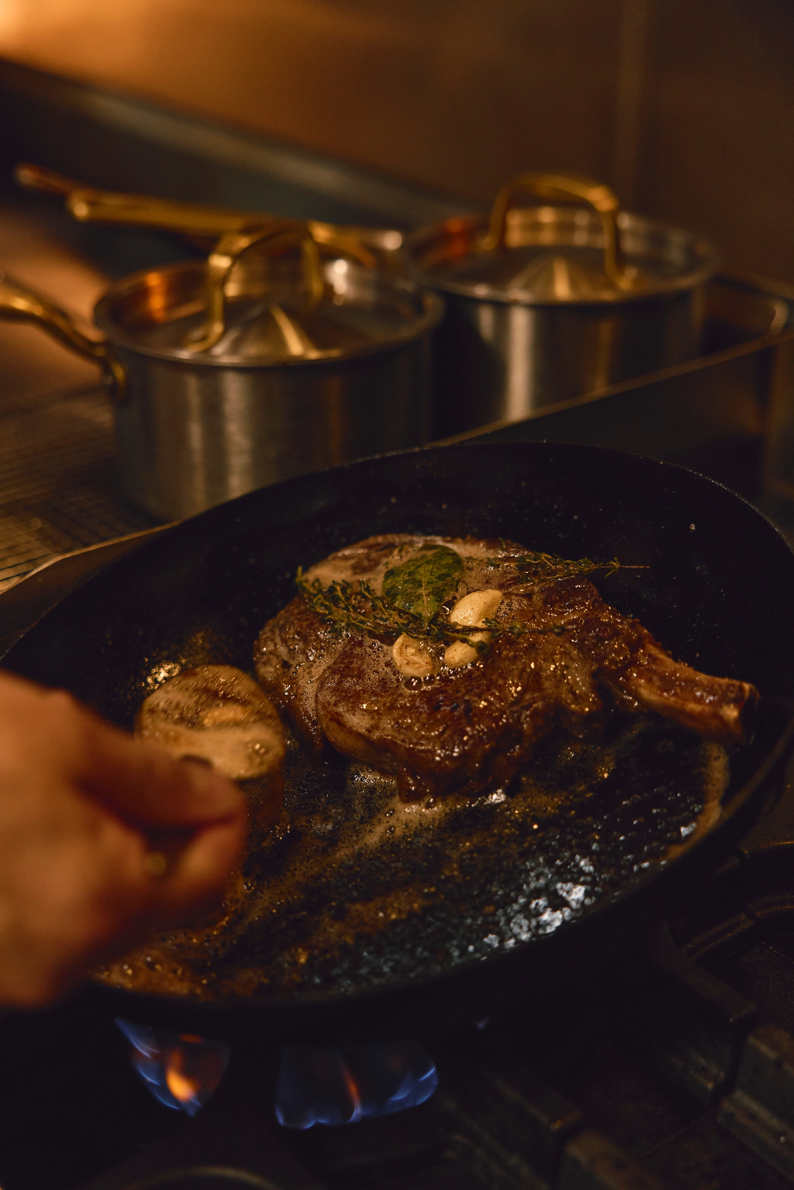 Sizzling steak in a cast iron skillet with herbs and garlic