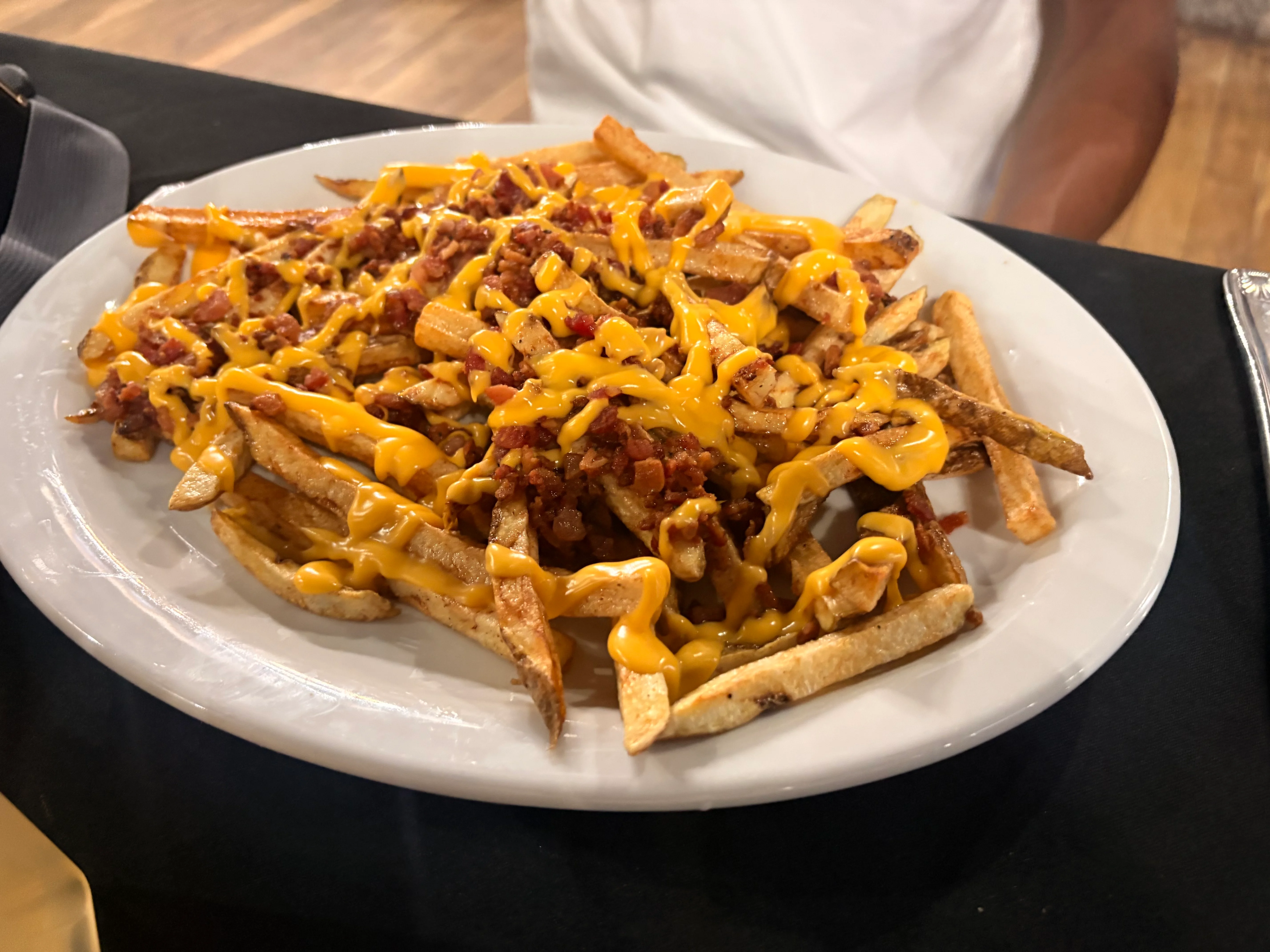 Loaded cheese fries topped with bacon bits, a popular American comfort food dish