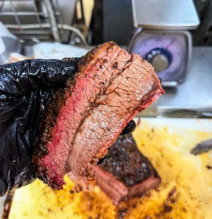 Sliced brisket showcasing perfect smoke ring and juicy texture
