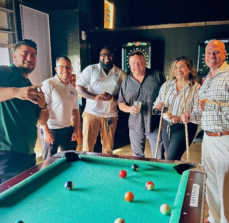 People playing pool in a lively restaurant setting.