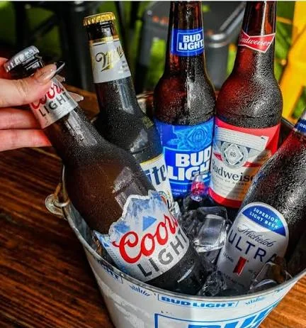 Chilled beer bottles in an ice bucket at a lively bar