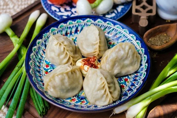 Plate of Tibetan momos with spicy dipping sauce