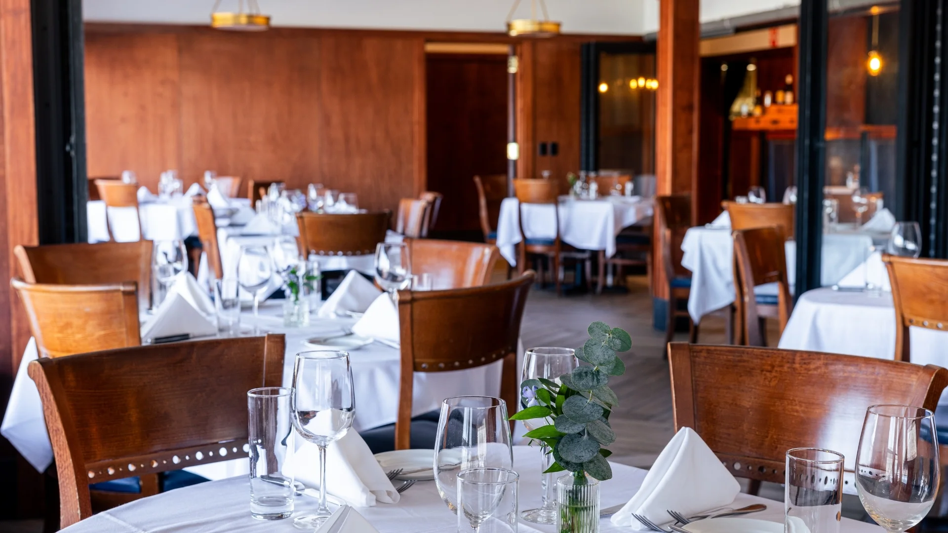 The Peregrine Room private dining space at Bass Street in Moline, IL — seats up to 30 guests with multiple dining tables