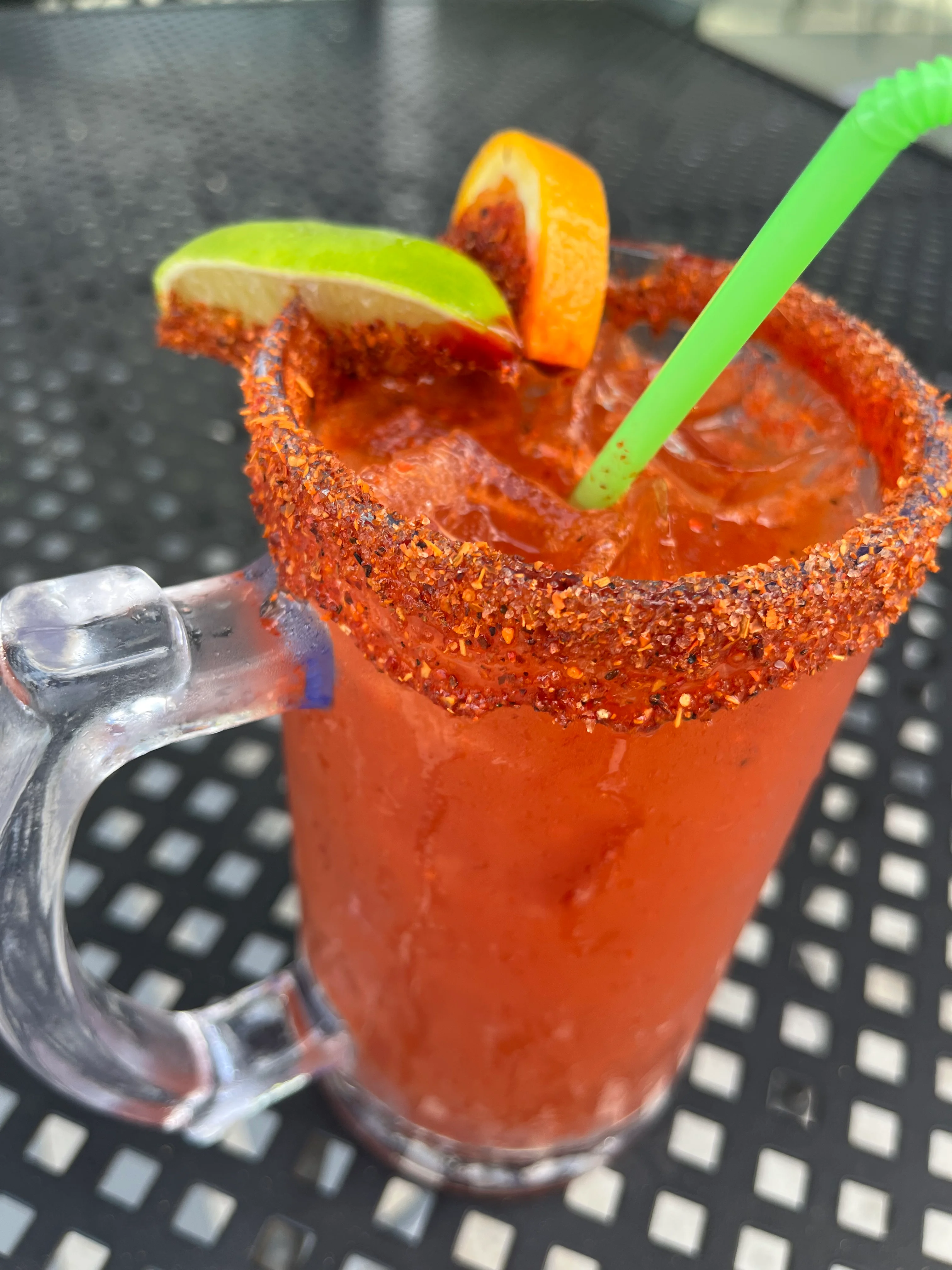 Spicy michelada cocktail with lime and orange garnish