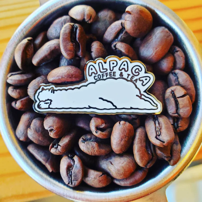 Coffee beans with Alpaca Coffee & Tea logo