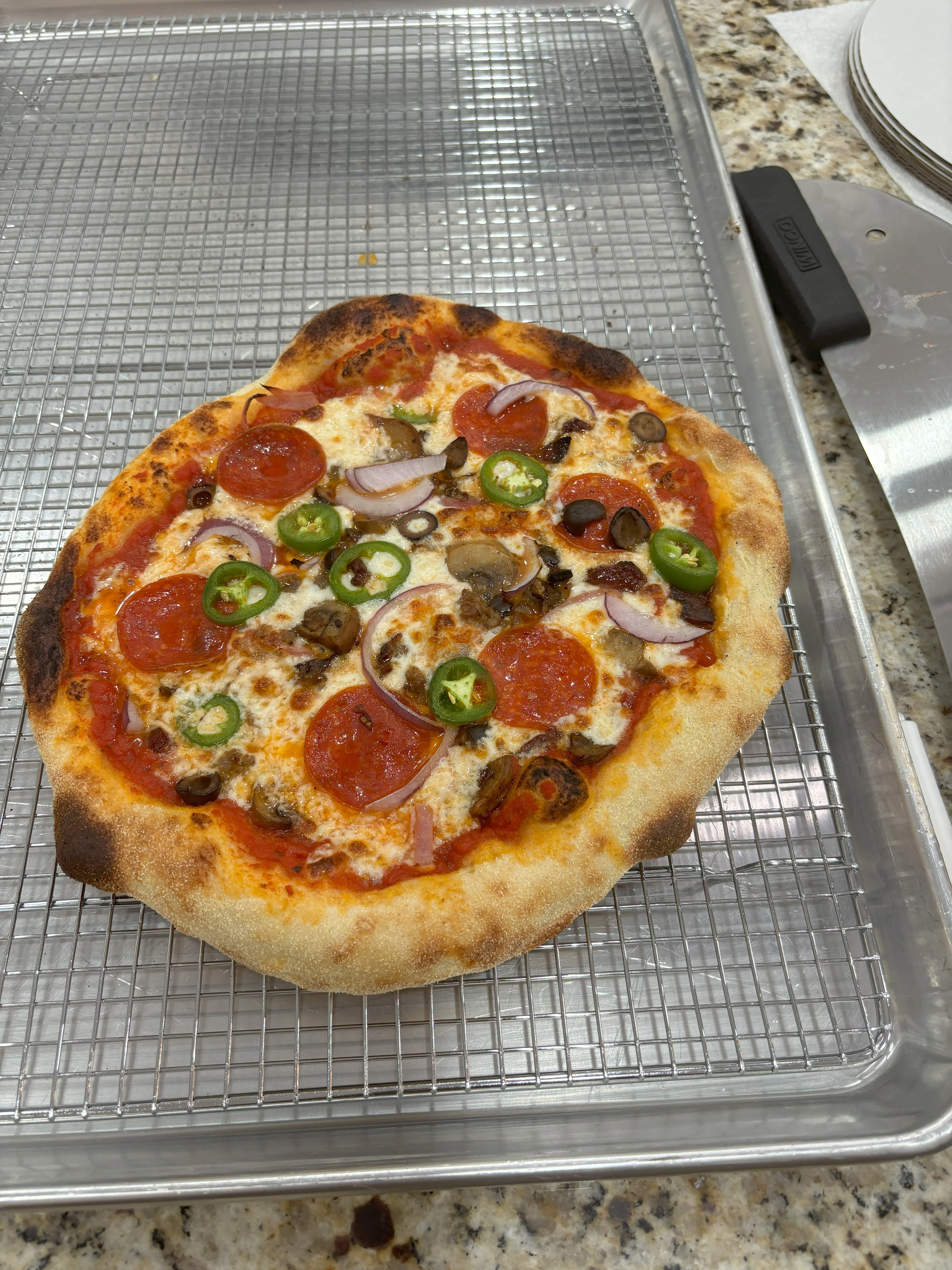 Pepperoni pizza with jalapeños and mushrooms