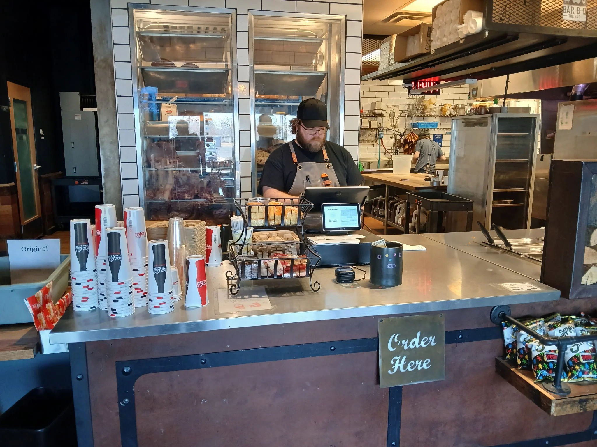 Restaurant counter with staff taking orders and food display