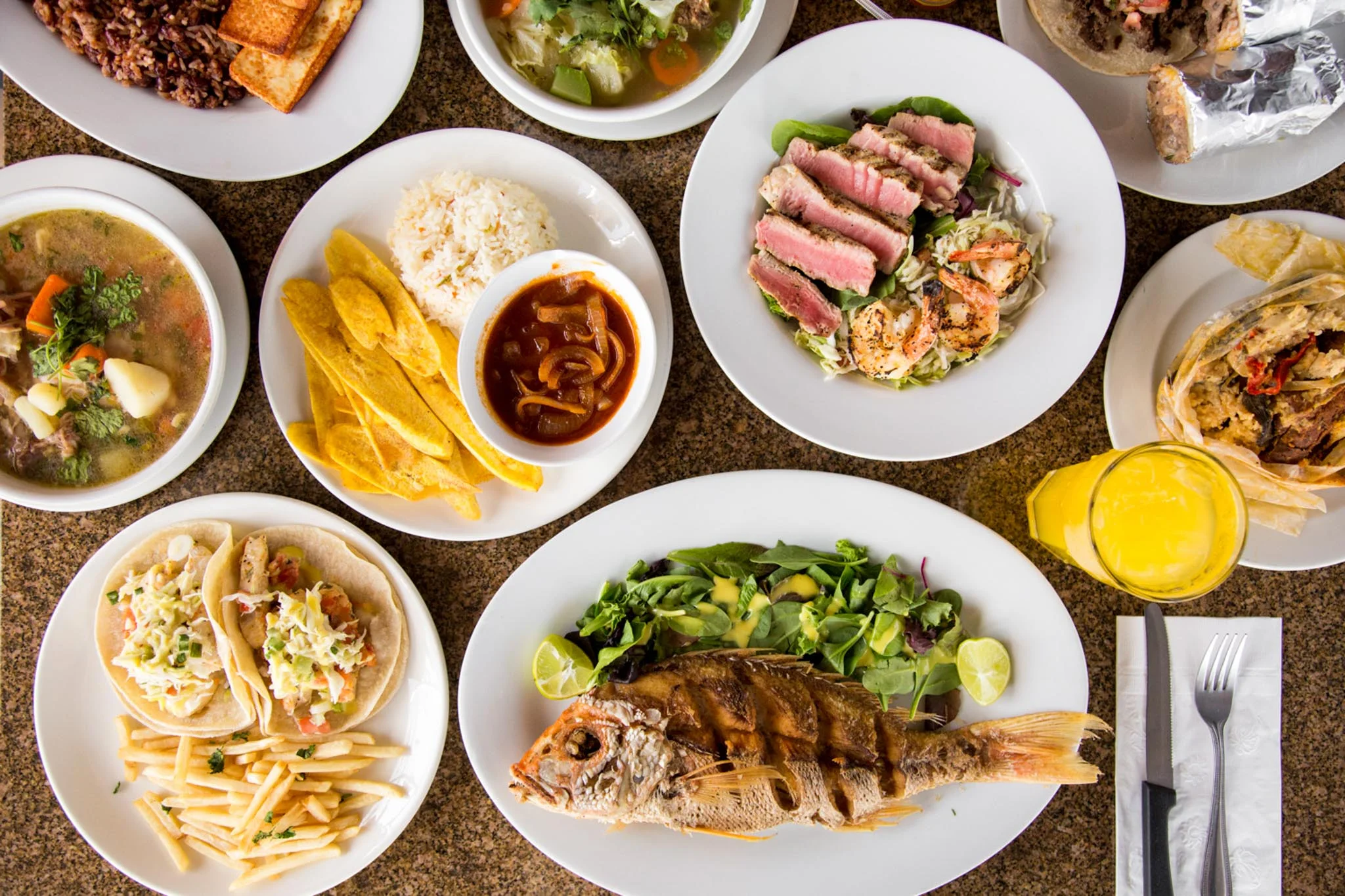 Assorted Latin American dishes including grilled fish and tacos