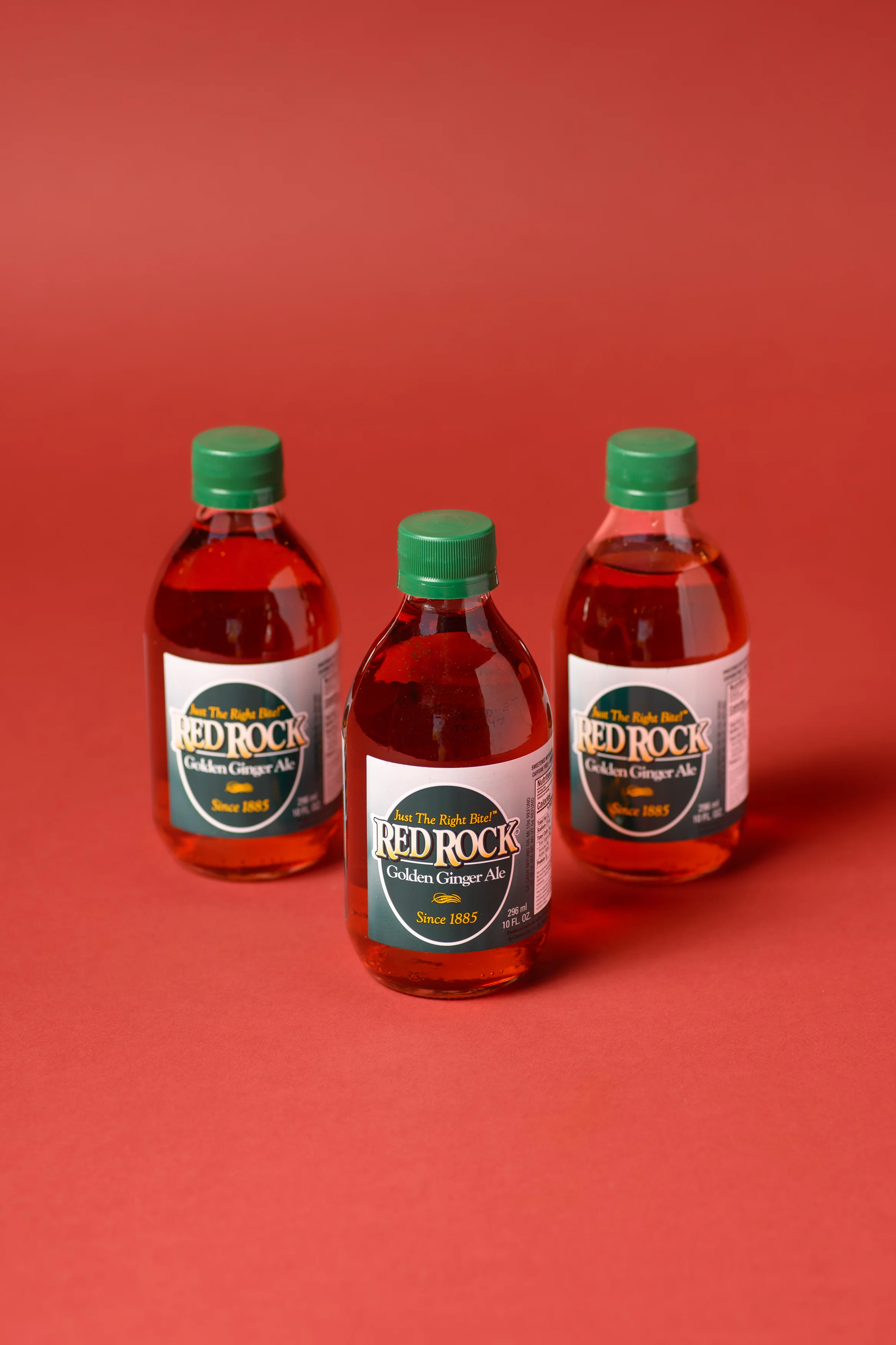 Bottles of Red Rock Golden Ginger Ale on a red background
