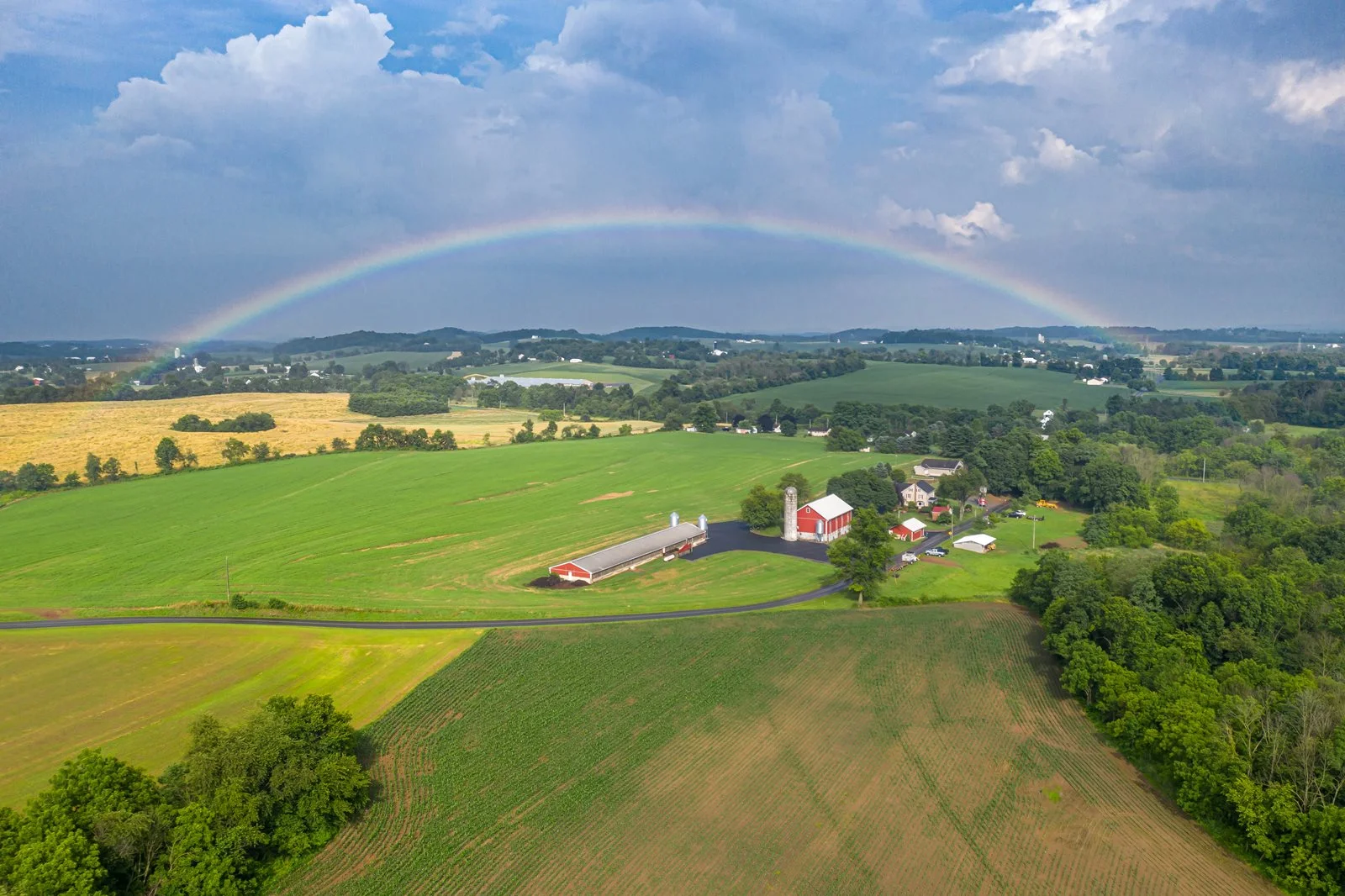 Aerial view of a vibrant farm landscape with a rainbow