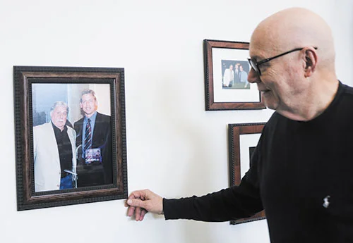 Man admiring a framed photo on the wall