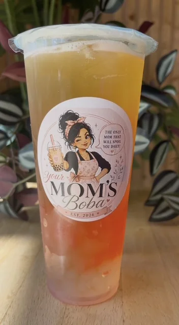 A refreshing layered drink featuring a blend of flavors with tapioca pearls at the bottom. The drink is presented in a transparent cup with a decorative label.