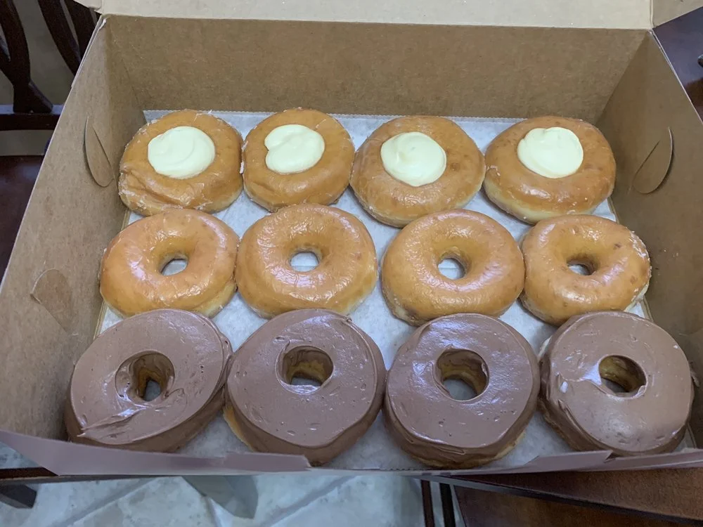 Box of assorted donuts with cream and chocolate frosting