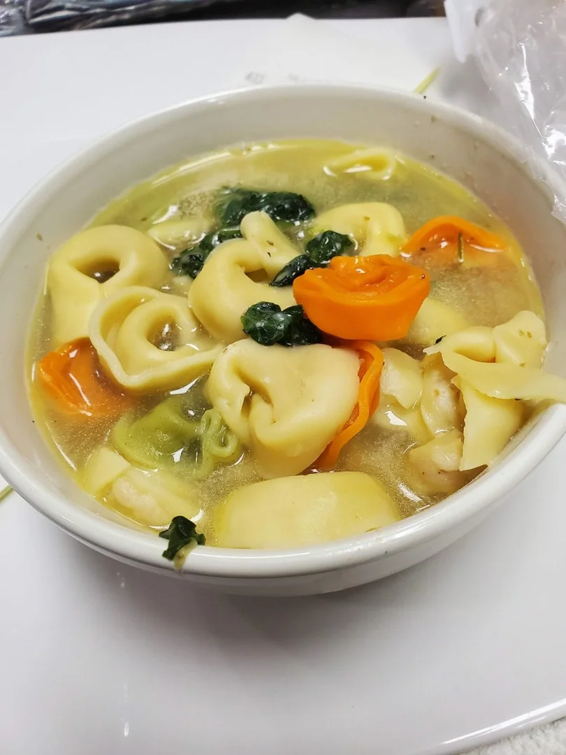 Italian tortellini soup with fresh greens