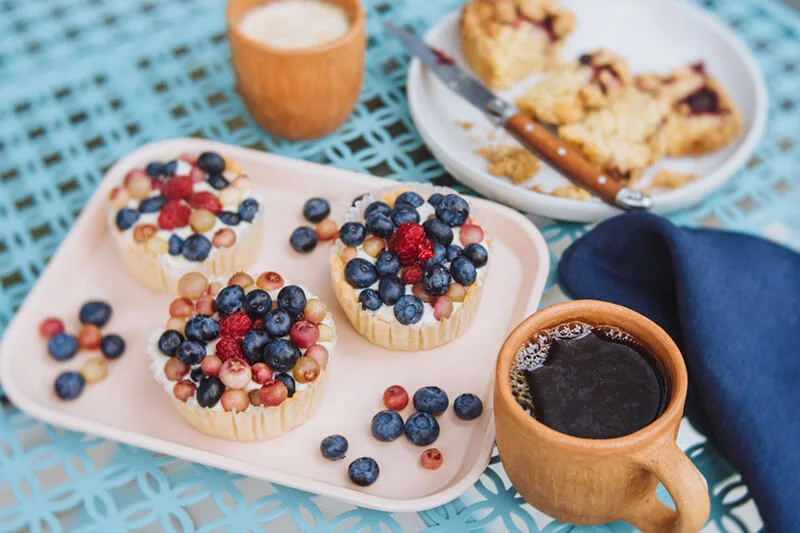 Delicious fruit tarts with berries on a pastel tray