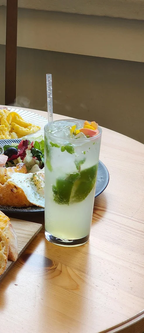 Cocktail with a plate of omelette beside it