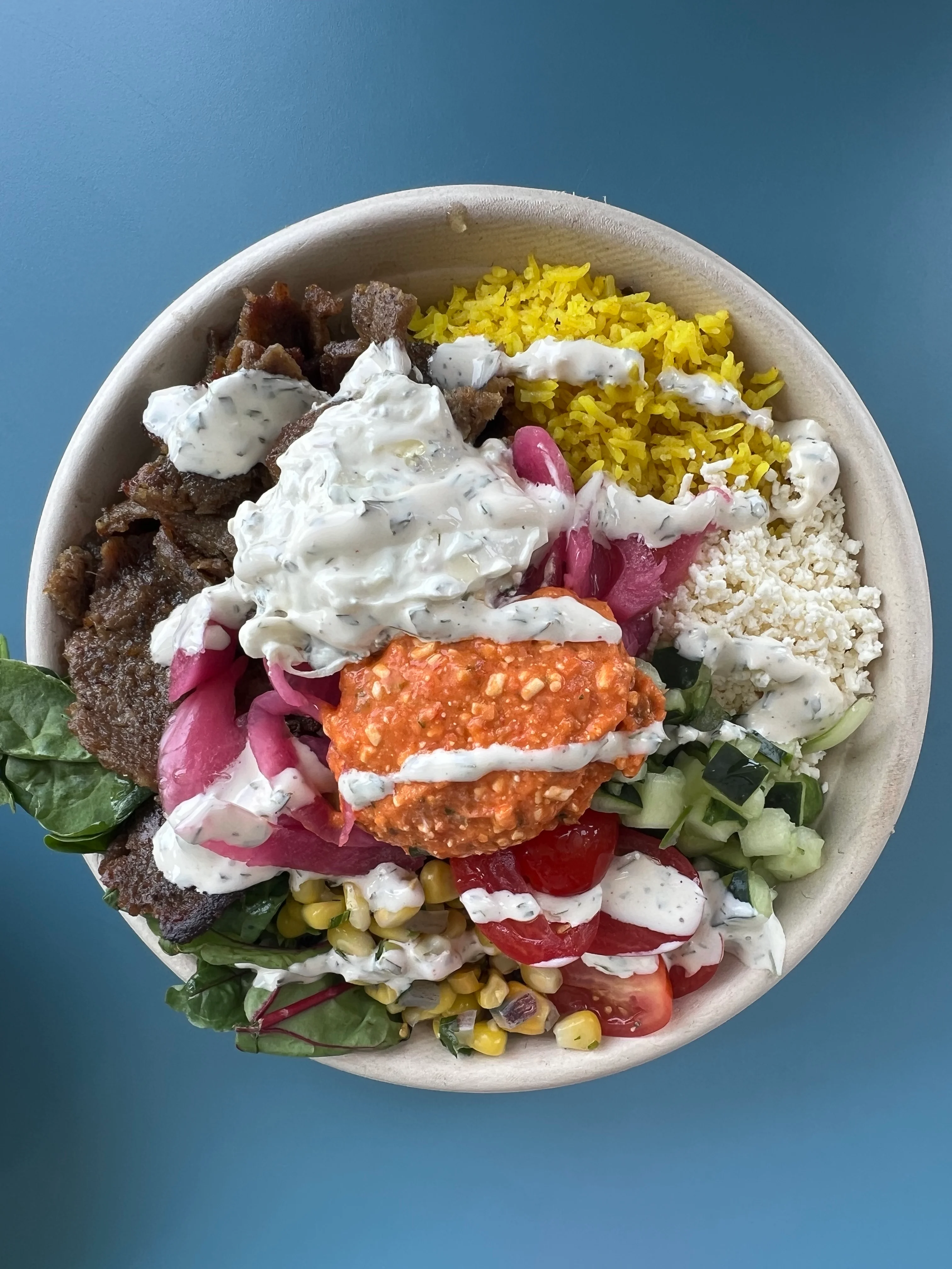 Mediterranean rice bowl with grilled meat and fresh toppings