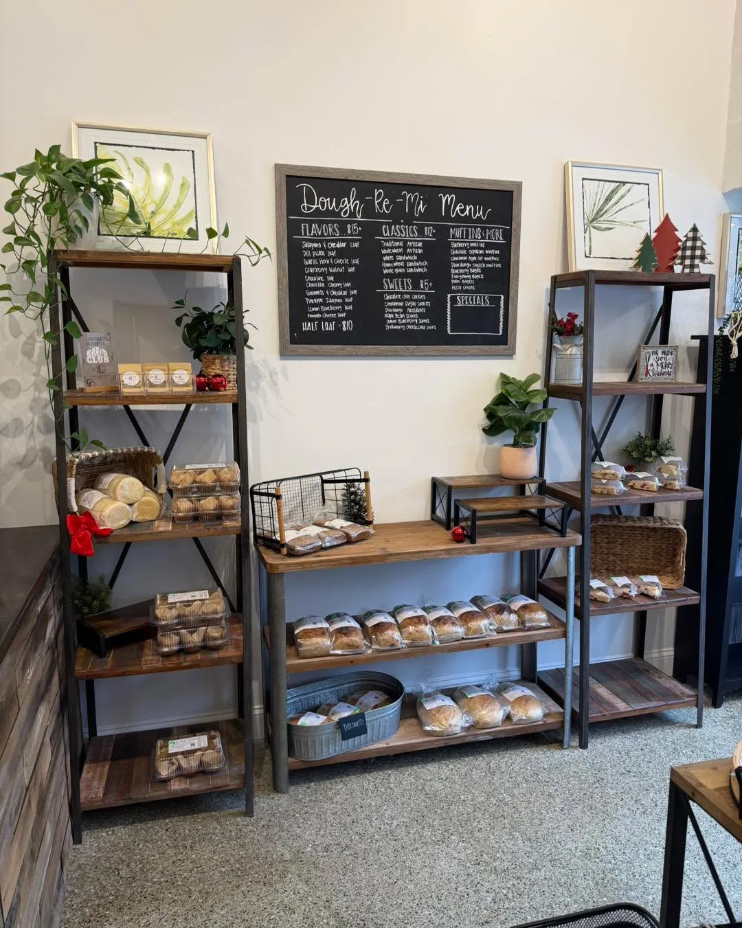 A cozy bakery display featuring a variety of baked goods, neatly arranged on wooden shelves with a menu board overhead.