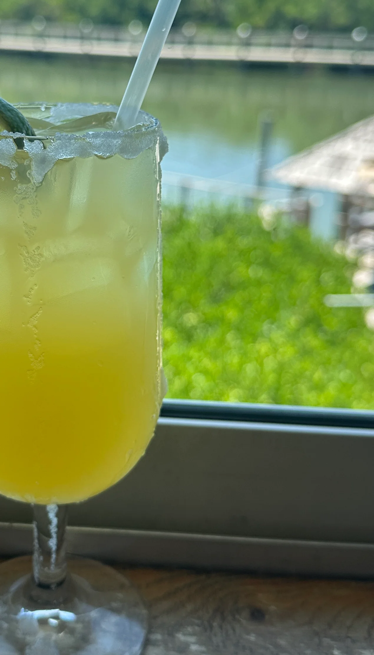 Refreshing tropical cocktail with lime garnish by the water