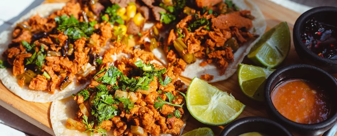 Aztec on Broadway Mexican Restaurant Portland - Al pastor tacos with cilantro and limes on wooden board