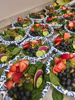 Colorful garden salad bowls with fresh fruits and greens